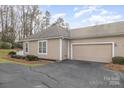 Exterior shot featuring a one-car garage with a driveway and tidy landscaping at 8107 Sultana Cir, Charlotte, NC 28227