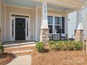 Inviting front porch with rocking chairs, decorative wreath, and stone pillar accents for a cozy welcome at 1016 Hickory Pine Rd, Waxhaw, NC 28173