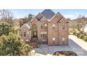 Stately brick home featuring a grand entrance with an arched window and a meticulously maintained front yard at 109 Dabbling Duck Cir, Mooresville, NC 28117