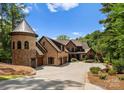 Beautiful brick home with a turret feature, a circular driveway, and a meticulously landscaped front yard at 1220 Broadside Rd, York, SC 29745