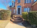 Inviting front entrance with brick steps leading to a black front door with palladian window at 159 S Gibbs Rd, Mooresville, NC 28117