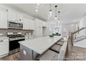 Bright kitchen featuring an island with seating, stainless steel appliances, and modern globe pendant lights at 205 Tillery Ln # 759, Mount Gilead, NC 27306