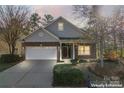 Inviting brick home featuring a two-car garage and well-lit walkway at 2439 Bergamot St, Fort Mill, SC 29708