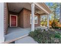 Charming front porch with a red door, brick accents, and a ceiling fan at 2439 Bergamot St, Fort Mill, SC 29708
