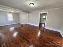Bright living room featuring hardwood floors, neutral paint, and a seamless transition to the adjacent carpeted area at 2507 Florida Ave, Kannapolis, NC 28083