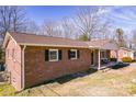 A well-maintained brick house featuring classic black shutters and a welcoming front porch at 3617 12Th Street Ne Dr, Hickory, NC 28601