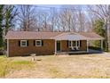 Charming brick ranch-style home with a covered porch and mature trees on a sunny day at 3617 12Th Street Ne Dr, Hickory, NC 28601