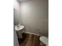 Powder room with pedestal sink and luxury vinyl plank flooring at 4116 Lurelin Ln, Charlotte, NC 28262