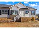 Charming single-story home with brick foundation, gray siding, and a welcoming front porch with white railings at 447 Lookout Dam Rd, Statesville, NC 28625