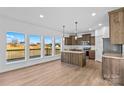 Modern kitchen with wood cabinets, stainless steel appliances, an island, and large windows for natural light at 447 Lookout Dam Rd, Statesville, NC 28625