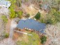 An aerial view of a home with a dark gray roof, surrounded by trees, and a long driveway at 630 Windsor Ne Pl, Concord, NC 28025