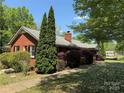 Charming one-story brick home with lush landscaping, mature trees, and a well-maintained lawn on a sunny day at 7107 Wilson Grove Rd, Mint Hill, NC 28227