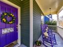 Charming porch with vibrant purple rocking chairs, creating a welcoming outdoor seating area at 7509 Thorn Creek Ln, Tega Cay, SC 29708