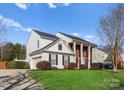 Classic two-story home with white siding, brick accents, and a well-kept lawn at 7720 Dinniston Dr, Huntersville, NC 28078