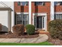 Inviting front entrance with brick facade, columns, and manicured landscaping at 7720 Dinniston Dr, Huntersville, NC 28078