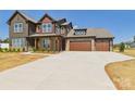 Spacious driveway leading to a beautiful home with a mix of stone and siding accents at 1030 Rolling Meadows Dr # Rm13, Mooresville, NC 28115