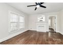 Inviting living room with hardwood floors, white trim, large windows, fireplace, and views into adjacent rooms at 1101 Lancaster Ave, Monroe, NC 28112
