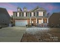 Charming two-story home with a brick and siding exterior, front porch, and a two-car garage at 121 Edgehill Ct, Troutman, NC 28166