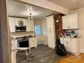 Well-lit kitchen with white cabinets, stainless steel appliances, and updated countertops at 1216 Innis Ave, Kannapolis, NC 28081