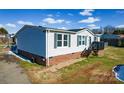 Home exterior featuring vinyl siding, brick foundation, walkway and wooden front deck with chairs at 1868 Ellick Dr, Newton, NC 28658