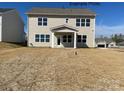 View of the backyard of a beige two-story home with a small, covered patio and ample lawn at 2216 Camber Dr # Cwo0074, Gastonia, NC 28054