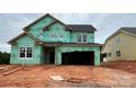 New home under construction with green weather resistant wrap, windows installed, and attached garage at 2216 Camber Dr # Cwo0074, Gastonia, NC 28054