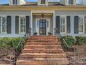 Inviting front entrance with brick steps, black shutters and a glass paneled front door at 3915 Ayscough Rd, Charlotte, NC 28211