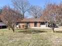 Traditional brick home with blue shutters and a well-maintained front lawn, radiating classic charm at 4069 Amsbury Rd, Concord, NC 28025
