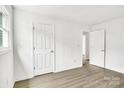 Bright bedroom featuring wood-look floors, doors, and neutral walls at 4501 Knollcrest Dr, Charlotte, NC 28208