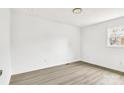 Bright, empty bedroom featuring wood-look floors, a window, and neutral walls at 4501 Knollcrest Dr, Charlotte, NC 28208