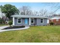 Charming single story house with a well maintained lawn and a light blue front door at 4501 Knollcrest Dr, Charlotte, NC 28208