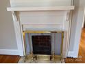 A close-up view of the fireplace and mantle with view into the kitchen and chandelier at 5135 Tucker Ave, Kannapolis, NC 28081