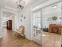 Open foyer with hardwood floors, leading to a bright office with glass door and decorative lights at 702 Yucatan Dr, Waxhaw, NC 28173