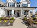 Inviting front porch showcasing stone pillars, a festive wreath, and outdoor seating at 702 Yucatan Dr, Waxhaw, NC 28173