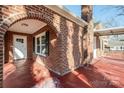 Enclosed brick porch featuring an arched doorway and red painted flooring, offering a touch of vintage charm at 801 Requa Rd, Cherryville, NC 28021