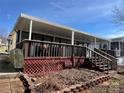 View of the home's covered back porch with surrounding wood railing and steps at 103 Dogwood Cir, New London, NC 28127