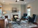 Bright living room with a decorative fireplace, stylish furnishings, and large windows for natural light at 1220 Avalon Pl, Matthews, NC 28104