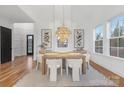 Elegant dining room with modern chandelier, light wood table, and white chairs, ideal for Gathering gatherings at 144 Sardis Ln, Charlotte, NC 28270