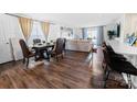Open-concept living space with a dining table, hardwood floors, and a breakfast bar at 1461 Forkhorn Dr, Monroe, NC 28110