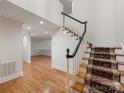 Inviting foyer with hardwood floors, staircase runner and view into adjoining room at 2027 Meadowood Ln, Charlotte, NC 28211