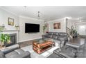 Inviting living room with a cozy fireplace, a large screen TV, and comfortable leather furniture at 2174 Black Forest Cv, Concord, NC 28027