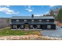 Stunning exterior of a black modern farmhouse with a metal roof, inviting porch, and manicured lawn at 2288 Boheler Rd, Clover, SC 29710