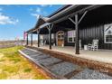 Charming front porch featuring rocking chairs, an American flag, and a rustic wooden front door with decorative wreaths at 2288 Boheler Rd, Clover, SC 29710
