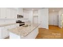 Open kitchen with white cabinets, granite counters, stainless appliances and wood floor at 3562 Nimbell Rd, Monroe, NC 28110