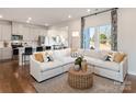 Bright living room with large windows, hardwood flooring, a comfortable couch and open to kitchen at 459 Olympia Way, York, SC 29745
