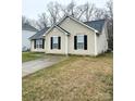 Charming one-story home with neutral siding, black shutters, a well-maintained lawn and a paved driveway at 5702 Burning Ridge Dr, Monroe, NC 28110