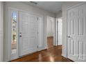 Bright entryway featuring hardwood floors, white trim, and a view into the living area at 5720 Parkstone Dr, Matthews, NC 28104
