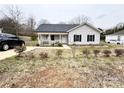 Well-maintained single-story home with a welcoming front porch and driveway, set against a cloudy sky at 601 Apple St, Gastonia, NC 28054