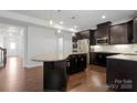 Open kitchen boasts a large island with granite countertops, stainless steel appliances, and dark cabinetry at 6112 Canyon Trl, Denver, NC 28037