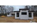 Angle of a modern home with white siding and black window trim on a cloudy day at 6855 Union Rd, Gastonia, NC 28056